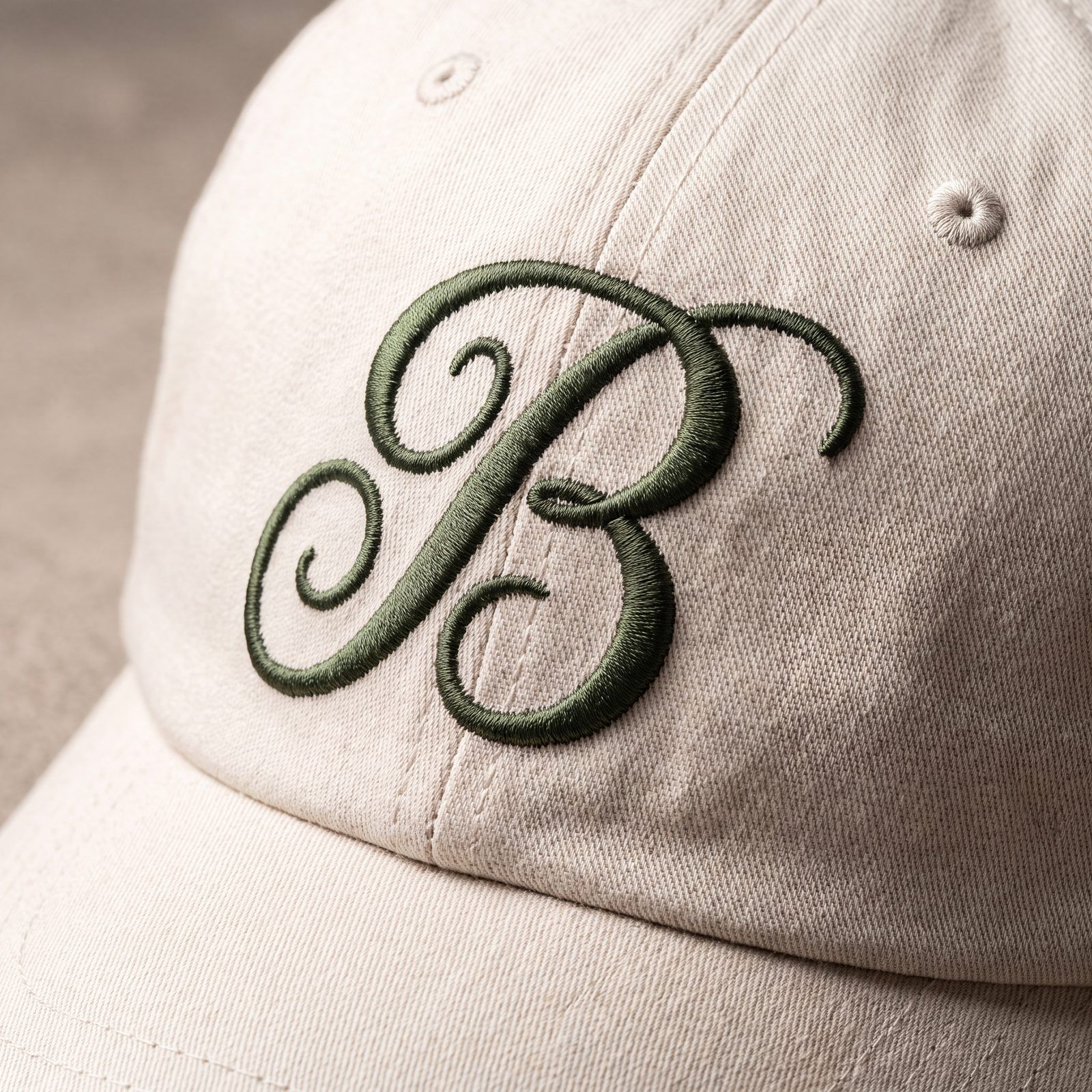 A bone cap with the Bolton B embroidered in moss thread